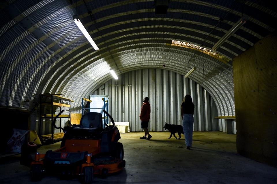 Sam Postema, left, and his daughter Samantha walk inside the curved barn on the property of the UFO-shaped home he and his partner Jennie Shire bought and are renovating on Wednesday, Sept. 27, 2023, in DeWitt Township.