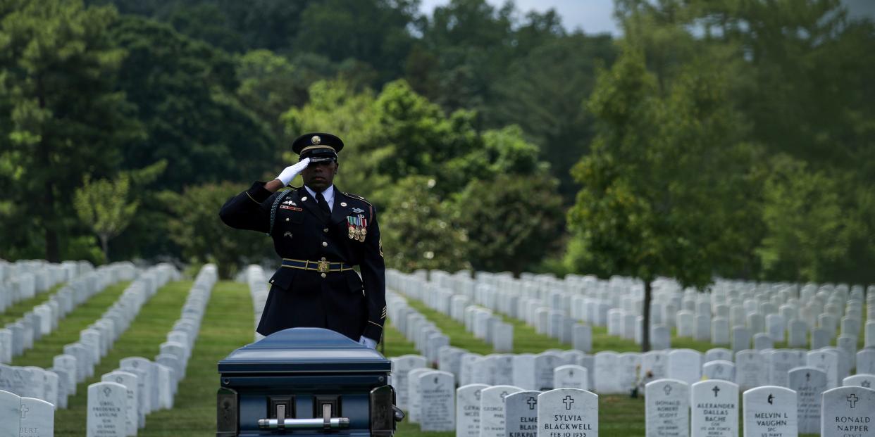 U.S. Army Sergeant Taylor salutes as World War II veteran Mann is laid to rest at Arlington National Cemetery