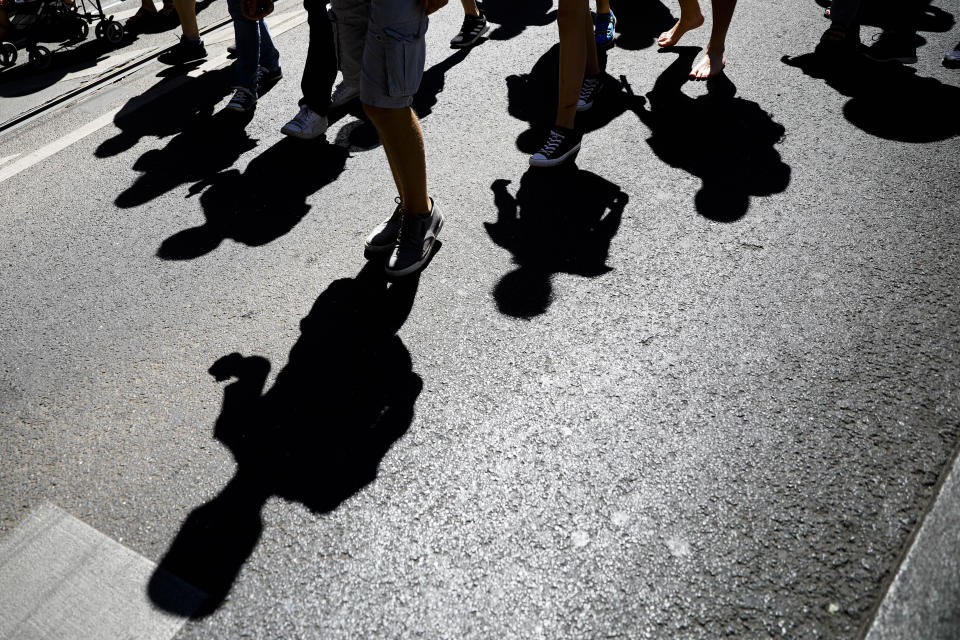 Protestors cast there shadow on the street as they attend a demonstration with the slogan ‚The end of the pandemic - freedom day' - against coronavirus restrictions in Berlin, Germany, Saturday, Aug. 1, 2020. It comes amid increasing concern about an upturn in infections in Germany. (AP Photo/Markus Schreiber)