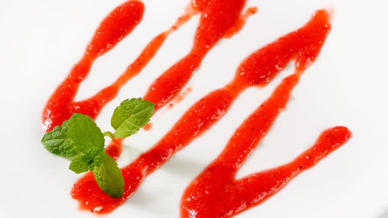 Red sauce squiggle with mint garnish