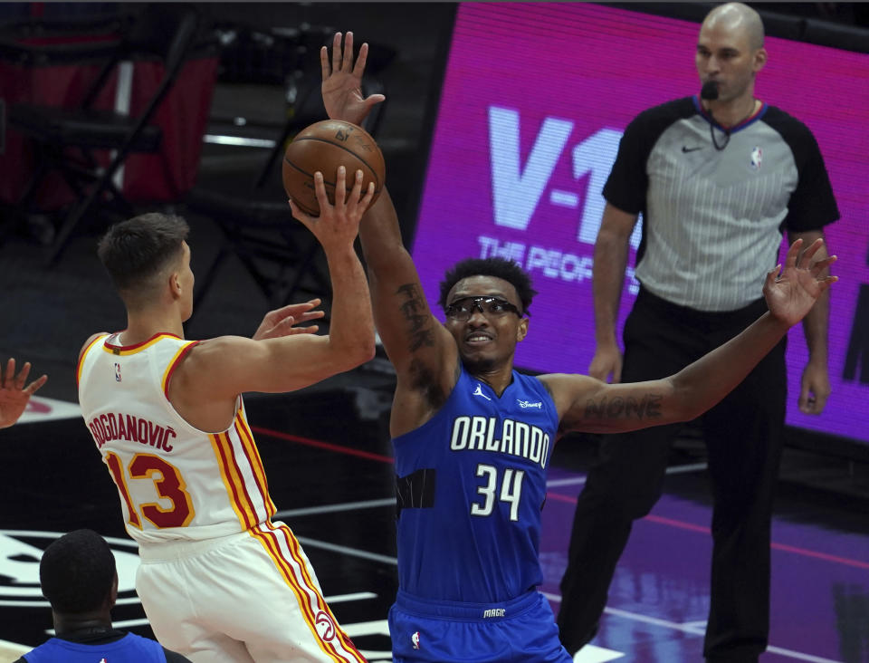 Atlanta Hawks shooting guard Bogdan Bogdanovic (13) shoots past Orlando Magic center Wendell Carter, Jr. (34) in the first half of an NBA basketball game Thursday, May 13, 2021 in Atlanta. (AP Photo/Tami Chappel)