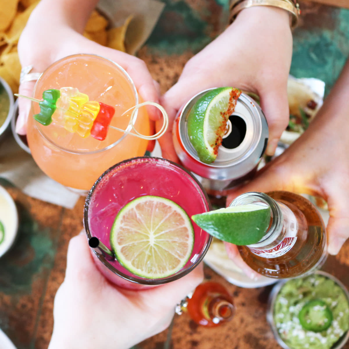 Woman cheersing with beers and cocktails