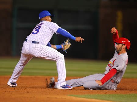 Apr 5, 2015; Chicago, IL, USA; St. Louis Cardinals third baseman Matt Carpenter (13) is caught stealing and tagged out by Chicago Cubs shortstop Starlin Castro (13) during the second inning at Wrigley Field. Dennis Wierzbicki-USA TODAY Sports