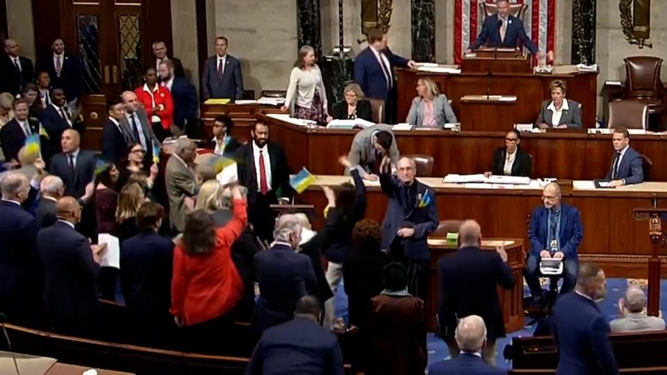 Representatives celebrate and wave flags after Congress passes Ukraine aid package (House TV/Reuters) (House TV/Reuters)