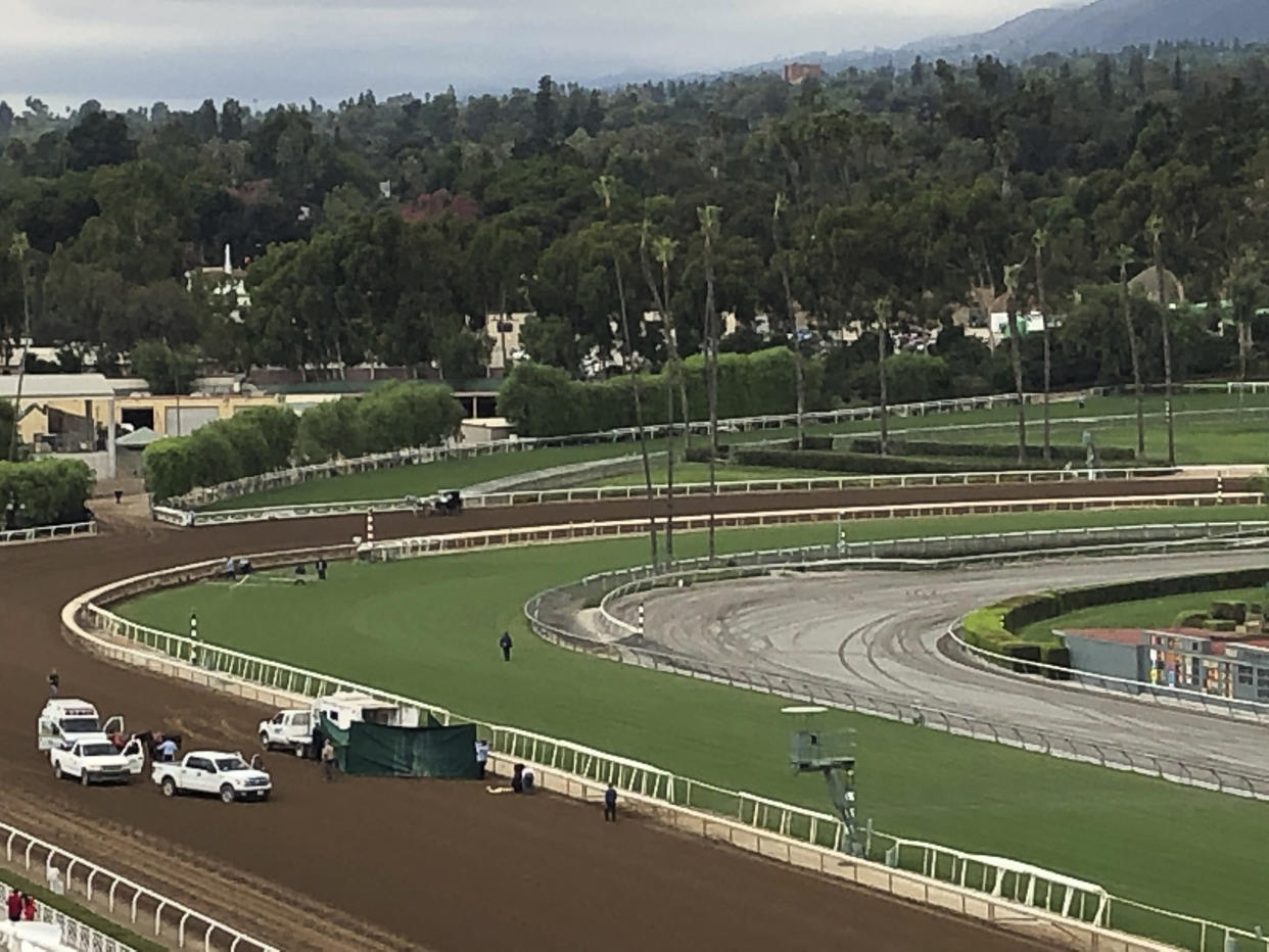 Track personnel attend Emtech, a 3-year-old colt, after he went down in the stretch at Santa Anita on Saturday. The colt as euthanized, marking the 32nd death at the racetrack since December.