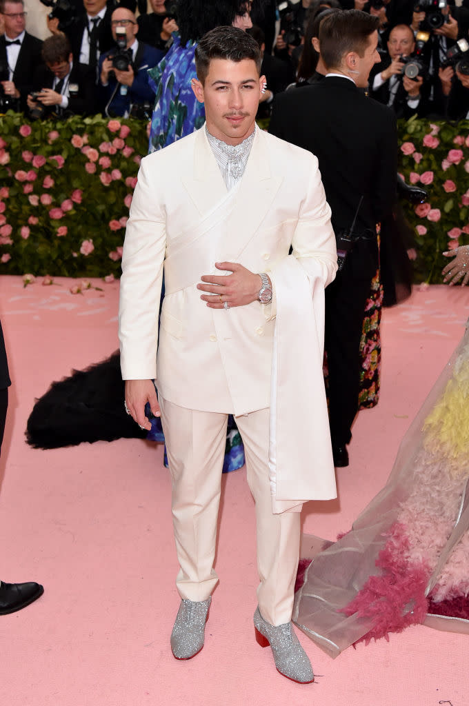 Nick Jonas in a double-breasted suit and silver sparkling shoes at an event