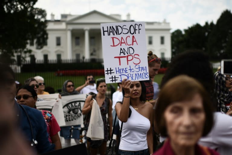 A woman holds a sign condemning the Trump administration's decision to rescind the DACA program granting amnesty for 800,000 young immigrants brought to the US illegally as minors