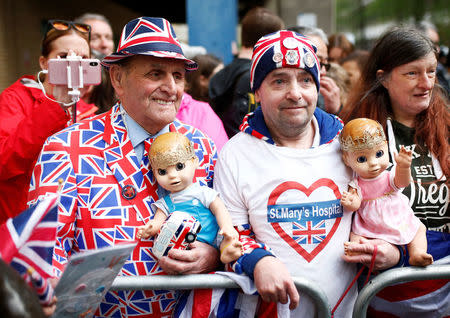 Two supporters of the royal family hold dolls wearing crowns as they stand outside the Lindo Wing of St Mary's Hospital after Britain's Catherine, the Duchess of Cambridge, was admitted after going into labour ahead of the birth of her third child, in London, April 23, 2018. REUTERS/Henry Nicholls