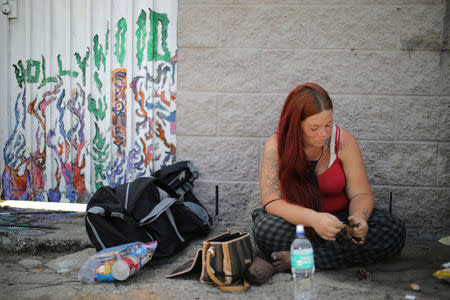 Maxx Hamilton, 27, who has been homeless for 12 years, sits on the street in Hollywood, Los Angeles, California, U.S. April 13, 2018. REUTERS/Lucy Nicholson