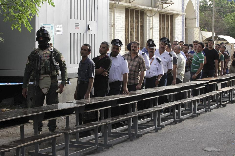 Iraqi security forces queue to vote outside a polling center in Baghdad, Iraq, Monday, April 28, 2014. Amid tight security, some one million Iraqi army and police personnel have started voting for the nation's new parliament. (AP Photo/Khalid Mohammed)