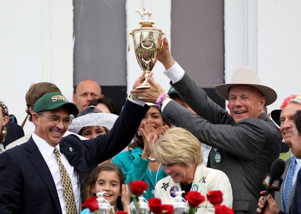 Kenny Troutt in a group of people in the winner's circle.