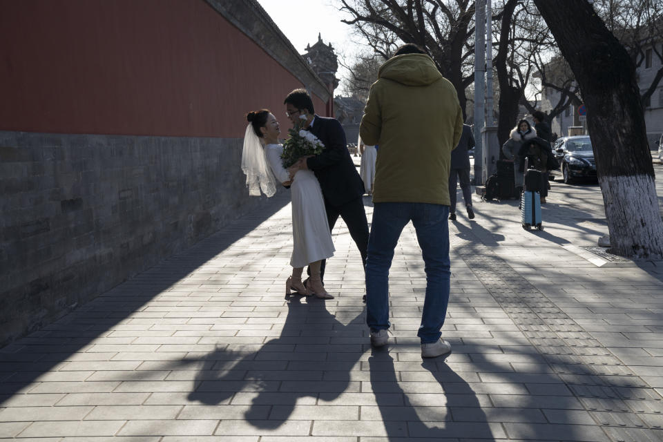 Groom Dong Yangfeng and bride Wang Sai pose for photos near the Forbidden City in Beijing Sunday, Dec. 20, 2020. Lovebirds in China are embracing a sense of normalcy as the COVID pandemic appears to be under control in the country where it was first detected. (AP Photo/Ng Han Guan)