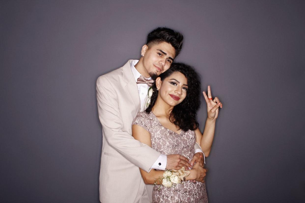 couple at prom, giving peace sign