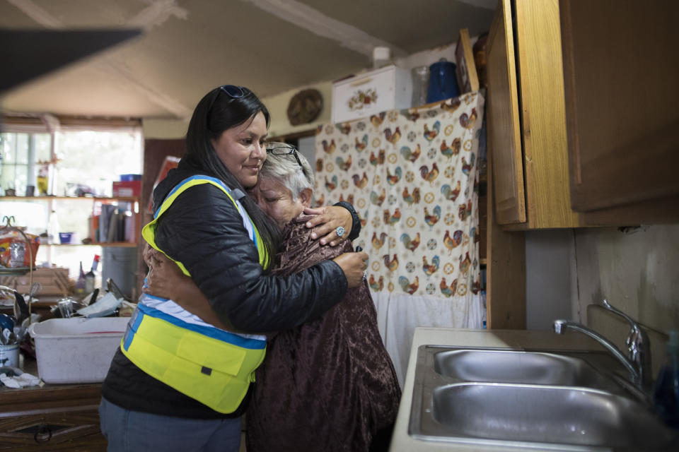 In this photo provided by DigDeep, Shanna Yazzie, project manager for the Navajo Mountain team of DigDeep's Navajo Water Project, left, hugs a client at a home in October 2022, near Navajo Mountain, Ariz. The U.S. Supreme Court will soon decide a critical water rights case in the water-scarce Southwest. The high court will hold oral arguments Monday, March 20, 2023, in a case with critical implications for how water from the drought-stricken Colorado River is shared and the extent of the U.S. government’s obligations to Native American tribes. (Nick Fojud/DigDeep via AP)