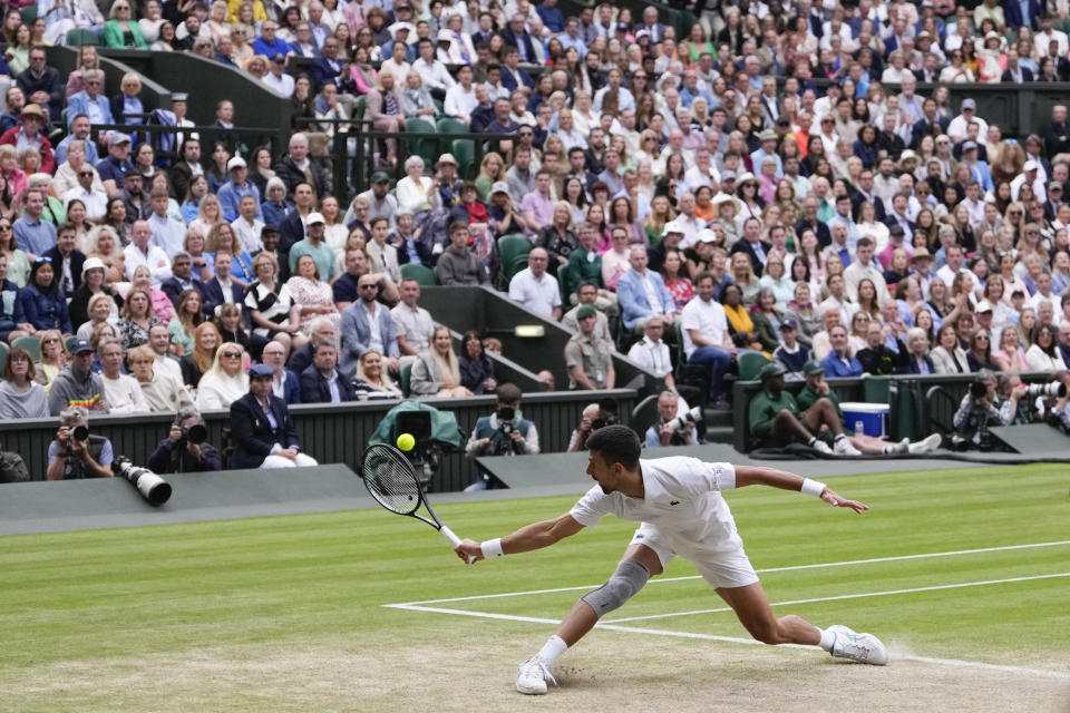 Novak Djokovic of Serbia plays a backhand return to Lorenzo Musetti of Italy during their semifinal match at the Wimbledon tennis championships in London, Friday, July 12, 2024. (AP Photo/Alberto Pezzali)