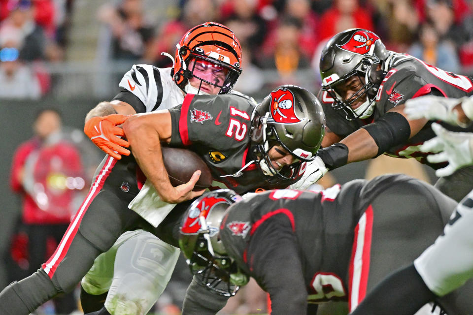 TAMPA, FLORIDA - DECEMBER 18: Logan Wilson #55 of the Cincinnati Bengals forces a fumble by Tom Brady #12 of the Tampa Bay Buccaneers during the third quarter at Raymond James Stadium on December 18, 2022 in Tampa, Florida. (Photo by Julio Aguilar/Getty Images)