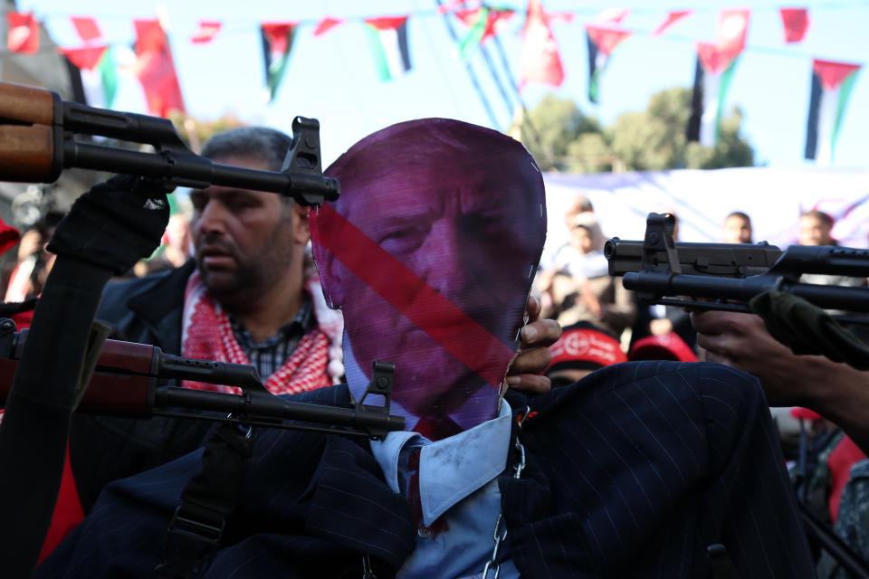 <p>Palestinian masked gunmen of the Popular Front for the Liberation of Palestine point their guns at an effigy of President Donald Trump, during a protest against President Donald Trump’s decision to recognize Jerusalem as Israel’s capital, in Gaza City, Saturday, Dec. 9, 2017. (Photo: Majdi Fathi/NurPhoto/Getty Images) </p>