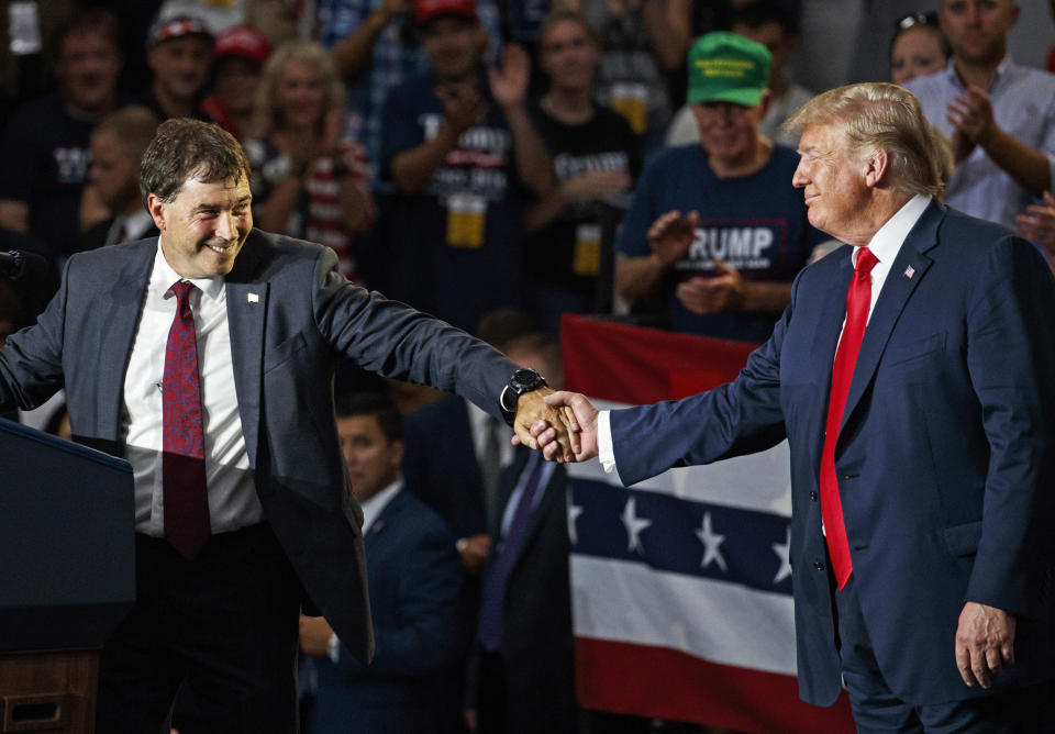 FILE – In this Aug. 4, 2018, file photo, Ohio state Sen. Troy Balderson, left, the Republican candidate running to succeed former Republican U.S. Rep. Pat Tiberi in Ohio's 12th District, clasps hands with President Donald Trump as Balderson speaks during a rally at Olentangy Orange High School in Lewis Center, Ohio. Balderson, a two-term state senator backed by Trump but who also promoted his ties to Trump critic Ohio Gov. John Kasich, has won a previously deadlocked congressional special election in Ohio, retaining a coveted open U.S. House seat long held by Republicans. (AP Photo/Carolyn Kaster, File)