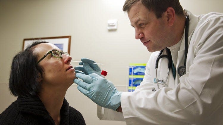 Dr. Ross Tobleman tests employee Katherine Voss for flu in Scott & White Hospital-Round Rock in 2018. Flu tests aren't as accurate as COVID-19 tests, which is why there isn't a home test like there is for COVID-19.
