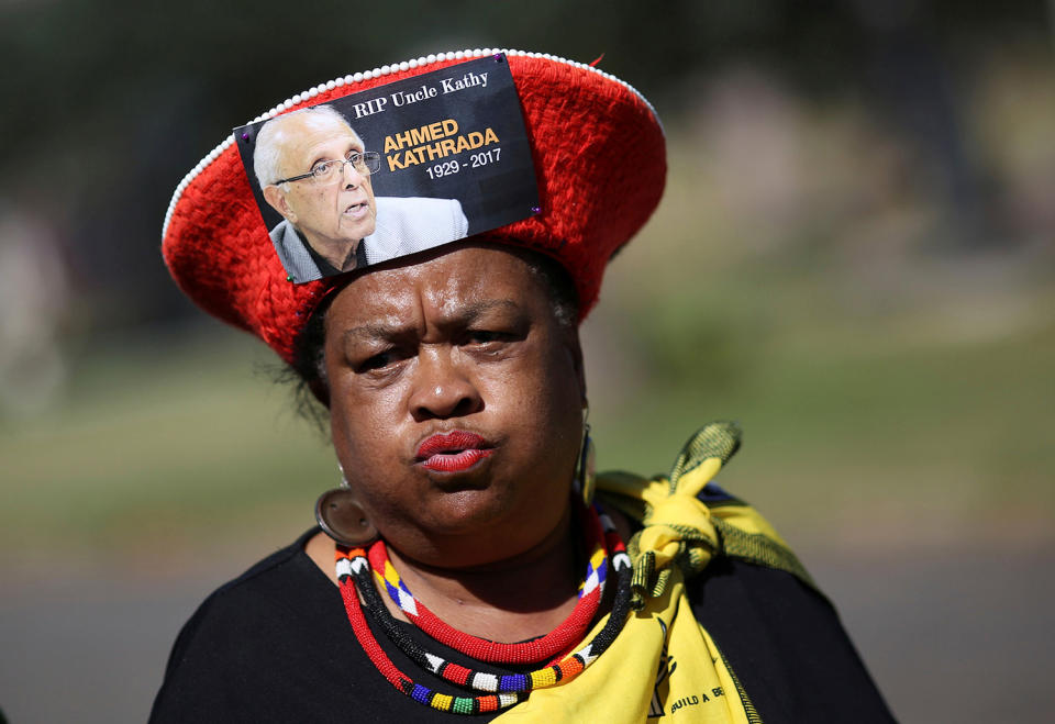 A mourner arrives wearing a hat bearing a picture of Ahmed Kathrada in Johannesburg