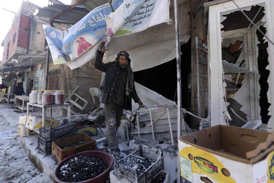 A man sorts through the damage to a shop in the the market in the city of Saraqeb in the Idlib countryside after an air strike by Syrian aircraft on Saturday, Dec. 21, 2019. Airstrikes on a rebel-held town killed several people and wounded more than a dozen in the northwestern province of Idlib, the last remaining rebel stronghold in the war-torn country, opposition activists said. The attack came amid a government offensive in the region. (AP Photo/ Ghaith al-Sayed)