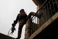 An Iraqi special forces soldier climbs a house during a battle with Islamic State militants in Mosul, Iraq March 2, 2017. REUTERS/Goran Tomasevic