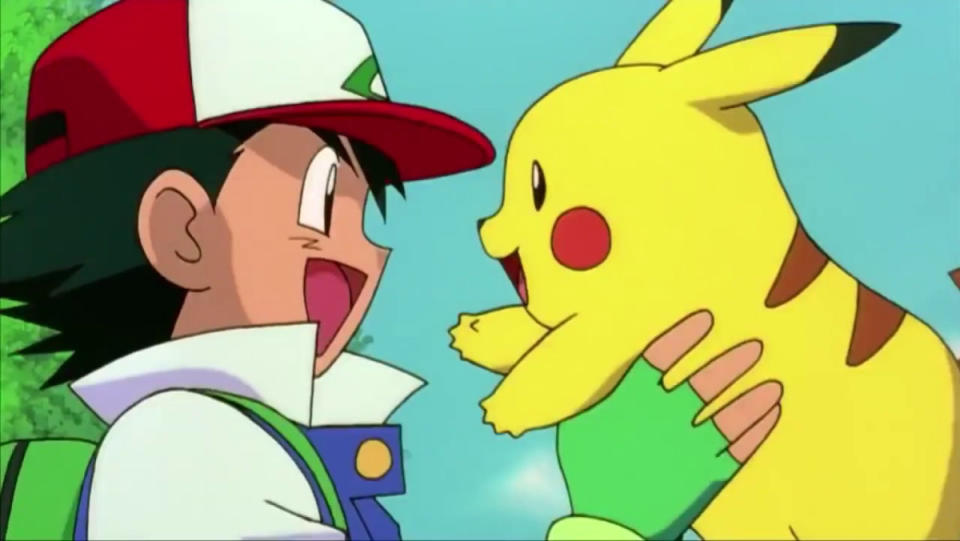 Ash holding up Pikachu