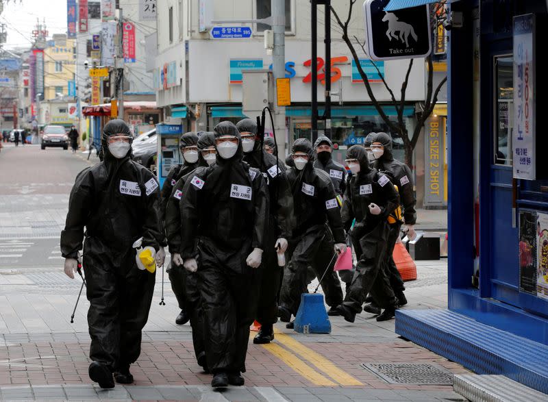 FILE PHOTO: South Korean soldiers in protective gear make their way while they disinfect buildings downtown, following the rise in confirmed cases of coronavirus disease (COVID-19) in Daegu