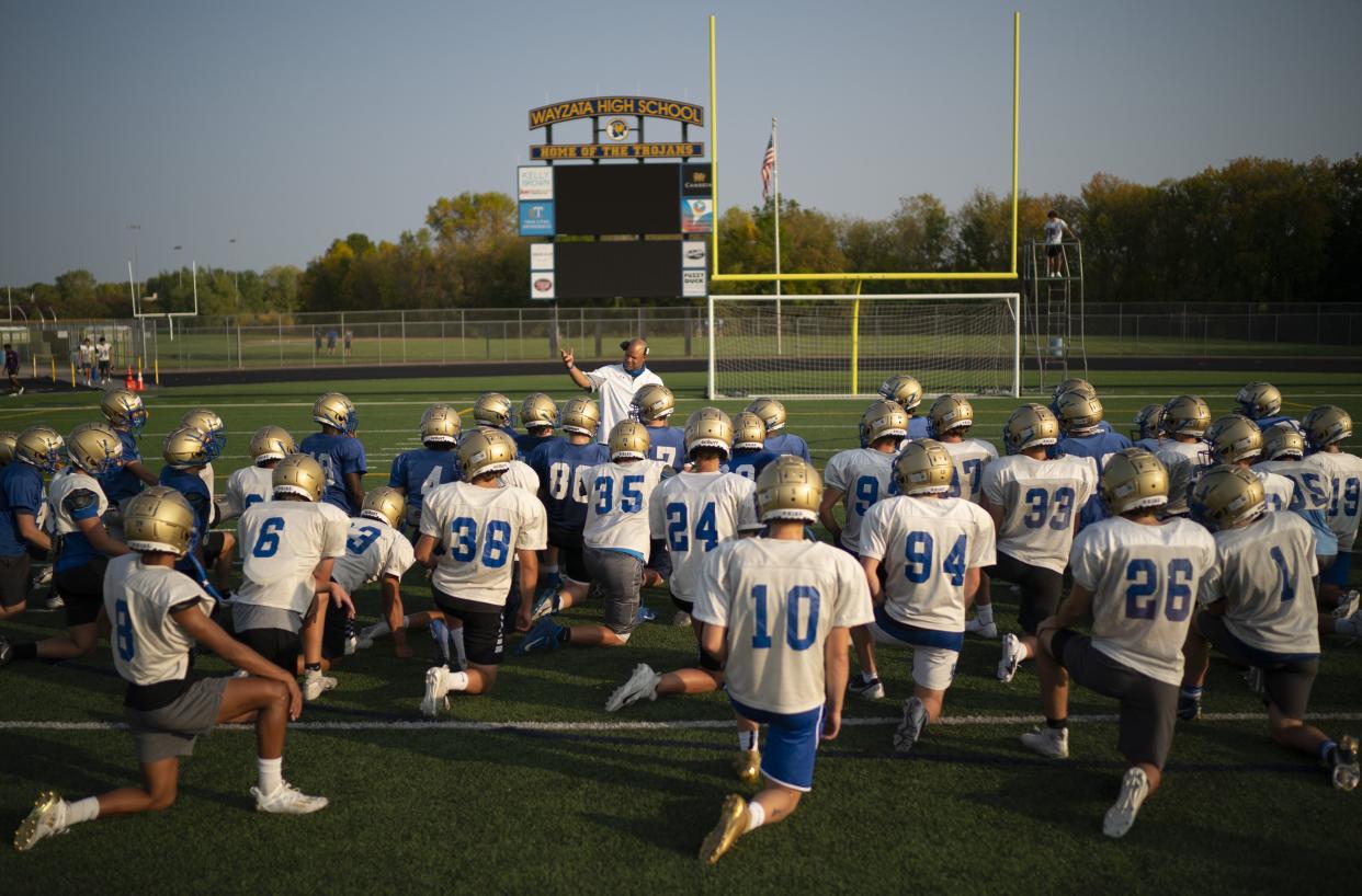 Wayzata High School football coach Lambert Brown gathers his players at the end of practice in Wayzata, Minn. on Monday, Sept. 21, 2020. The Minnesota State High School League voted to allow football and volleyball teams to play for the fall season.