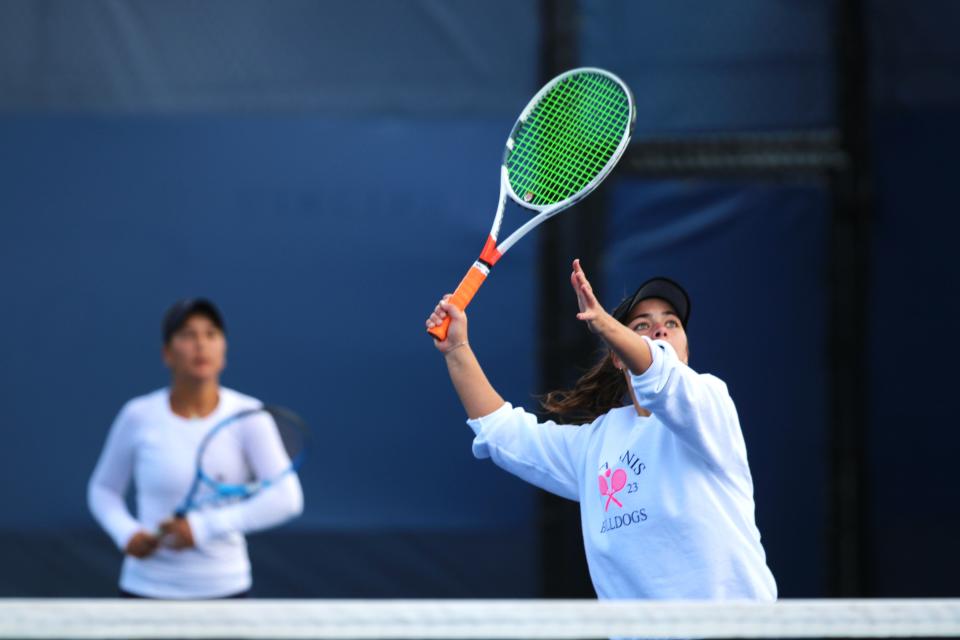 St. Ursula senior Elle Schuermann hits the ball in doubles with teammate Emily Jennewein in doubles during the OHSAA sectional girls tennis tournament Saturday, Oct. 7 at the Lindner Family Tennis Center in Mason, Ohio.