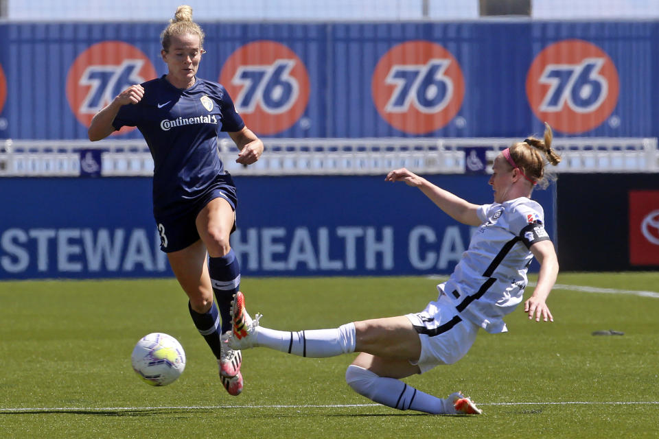 North Carolina Courage forward Kristen Hamilton (23) drives as Portland Thorns FC defender Becky Sauerbrunn (4) slides in with a challenge during the first half of an NWSL Challenge Cup soccer match at Zions Bank Stadium Saturday, June 27, 2020, in Herriman, Utah. (AP Photo/Rick Bowmer)