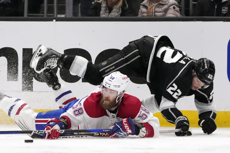 Montreal Canadiens defenseman David Savard (58) reaches for the puck under Los Angeles Kings left wing Kevin Fiala (22) during the second period of an NHL hockey game Thursday, March 2, 2023, in Los Angeles. (AP Photo/Marcio Jose Sanchez)
