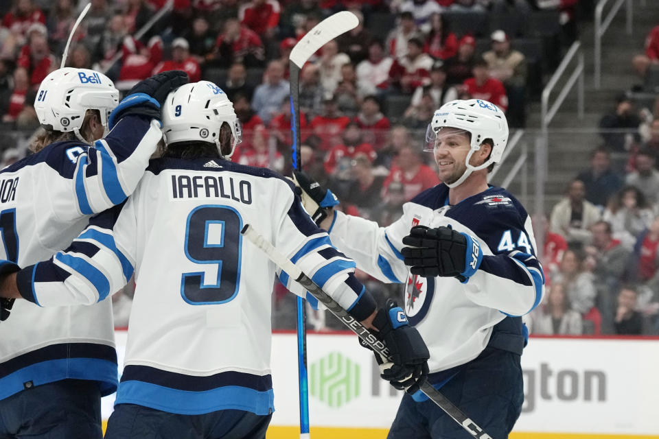 Winnipeg Jets defenseman Josh Morrissey (44) celebrates a goal by left wing Kyle Connor, left, during the first period of an NHL hockey game against the Detroit Red Wings, Thursday, Oct. 26, 2023, in Detroit. (AP Photo/Carlos Osorio)