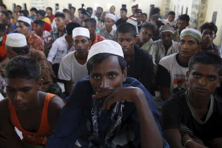 A group of Rohingya and Bangladeshi migrants, who arrived in Indonesia by boat this week, sit after arriving at a new shelter in Lhoksukon, Indonesia's Aceh Province May 13, 2015. REUTERS/Roni Bintang