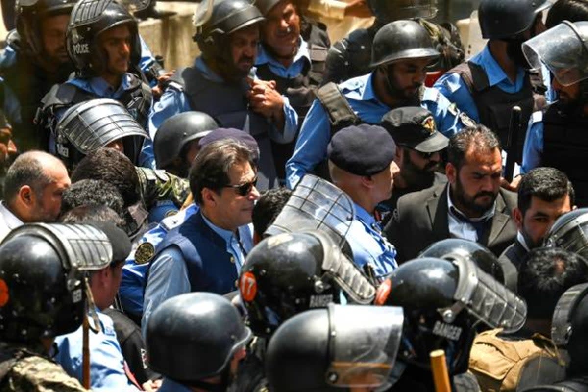 Policemen escort Pakistan’s former prime minister Imran Khan as he arrives at the high court in Islamabad on 12 May 2023 (AFP via Getty Images)