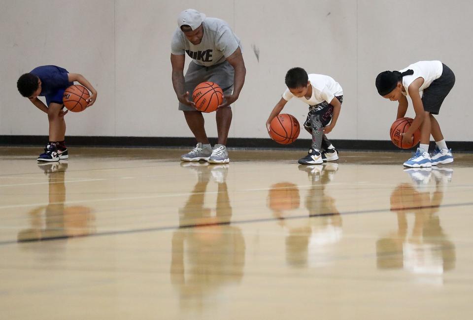 Commit 360 assistant coach JacQuan McWhorter leads young players in a ball-handling drill.