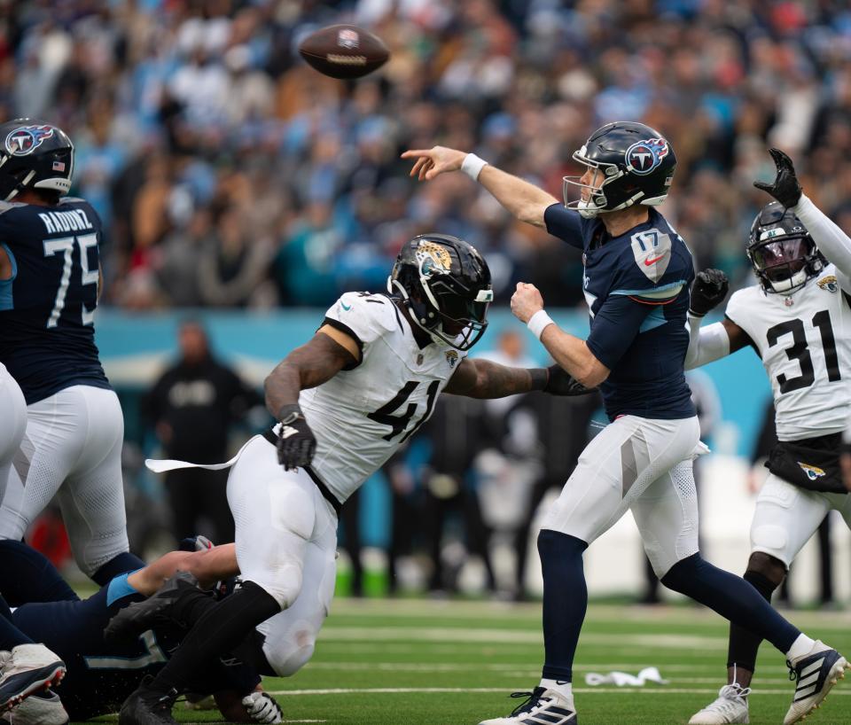 With Jacksonville Jaguars outside linebacker Josh Allen (41) closing in,, Tennessee Titans quarterback Ryan Tannehill (17) gets off a pass during Sunday's 28-20 victory that knocked the Jaguars out of the NFL playoffs and out of winning another AFC South title.