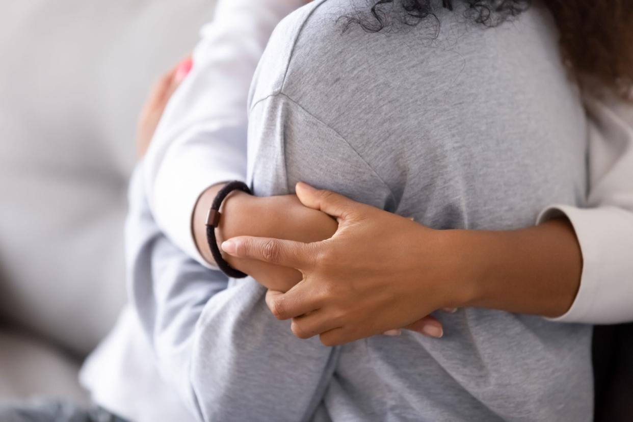 Loving foster mother embraces teen.