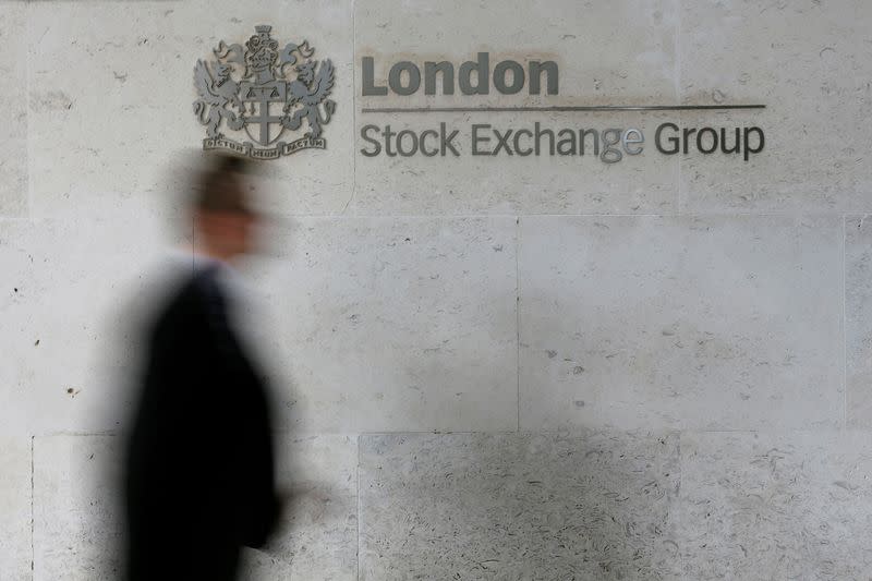 FILE PHOTO: A man walks past the London Stock Exchange in the City of London