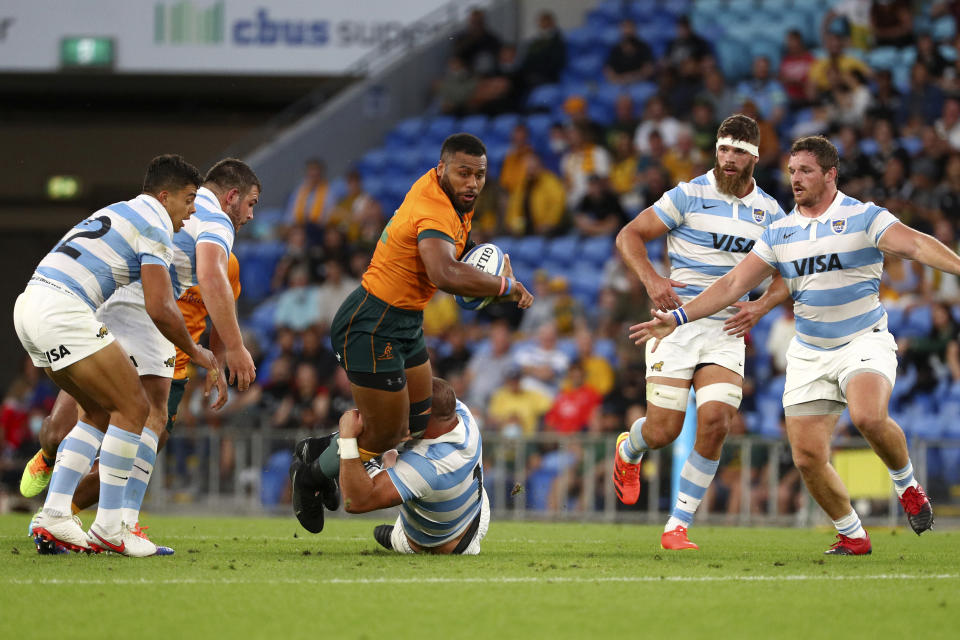 Australia's Samu Kerevi, center, is tackled by Argentina's Rodrigo Martinez during their Rugby Championship test match on the Gold Coast, Australia, Saturday, Oct. 2, 2021. (AP Photo/Tertius Pickard)