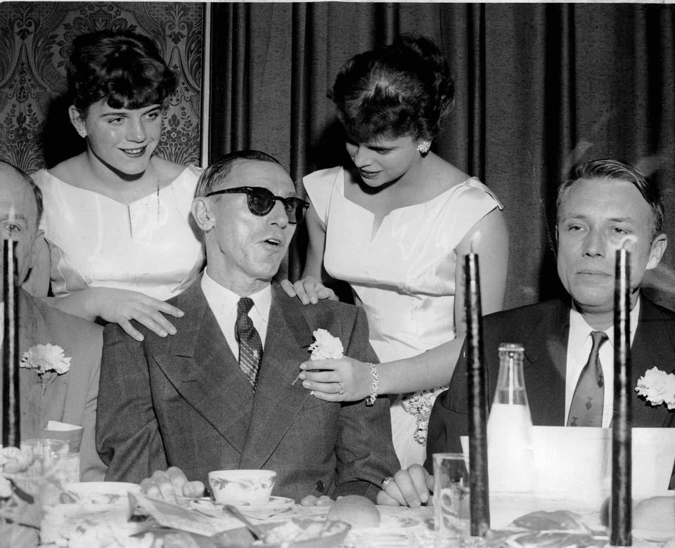 Doris Fuchs, left, and her sister Ingeborg put a carnation in buttonhole of Specs Torporcer, Rochester Red Wings All-Time player, at Press-Radio Polio Dinner at the Powers Hotel in 1957. The Fuchs sisters competed in gymnastics in the Olympics.