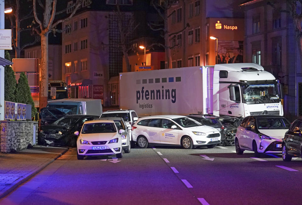 In this Monday, Oct. 7, 2019 photo s truck stands between damaged cars in Limburg, Germany. The truck drove into a line of eight cars in Limburg late Monday afternoon, pushing the vehicles into each other. Police said seven people were taken to hospitals and the driver also was slightly injured. He was detained. (Thorsten Wagner/dpa via AP)