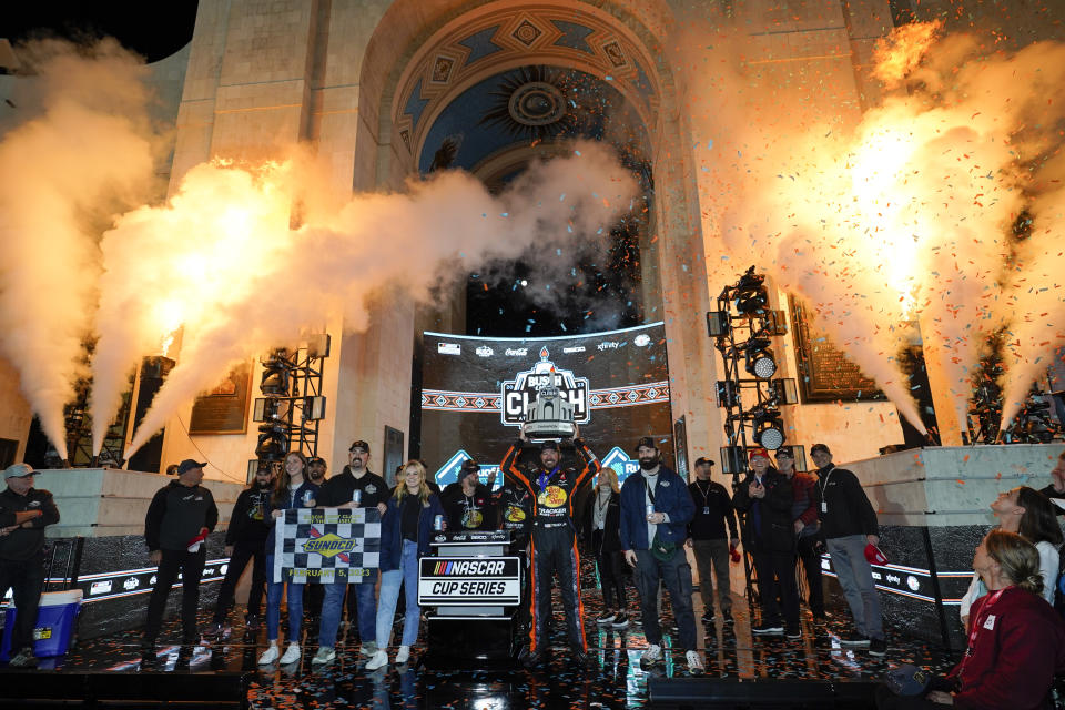 NASCAR Cup Series driver Martin Truex Jr. (19) poses for a photo with the championship trophy after winning a NASCAR exhibition auto race at Los Angeles Memorial Coliseum, Sunday, Feb. 5, 2023, in Los Angeles. (AP Photo/Ashley Landis)