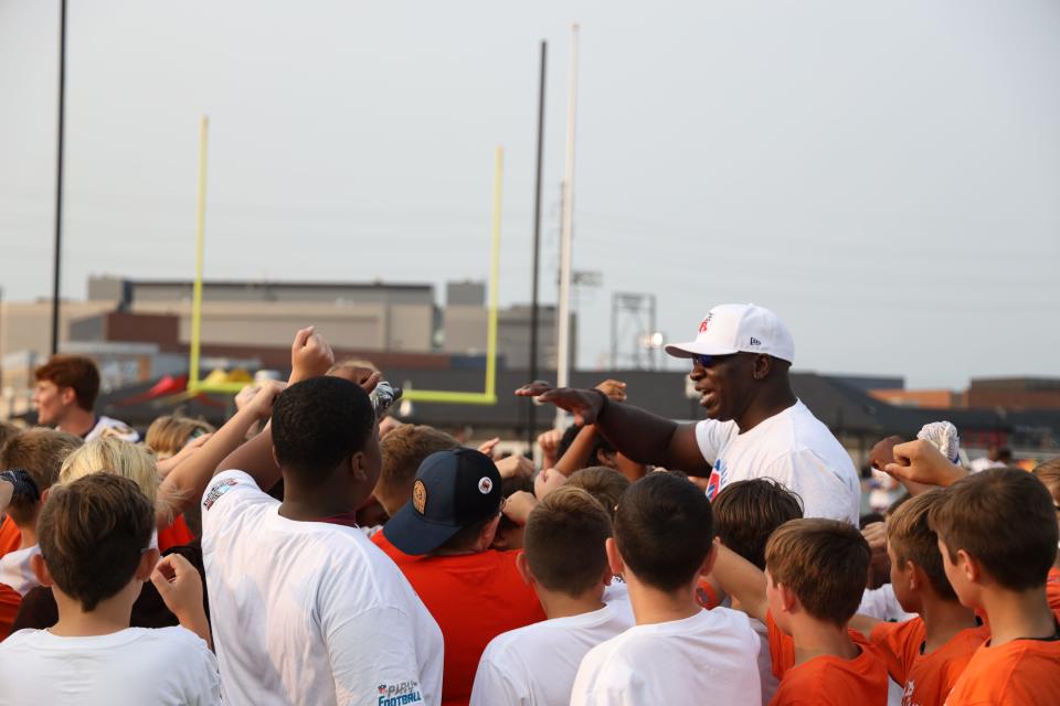 Pro Football Hall of Famer John Randle talks to kids during the Play Football Skills Camp at the Hall of Fame Village's ForeverLawn Sports Complex, Tuesday, Aug. 1, 2023, in Canton.