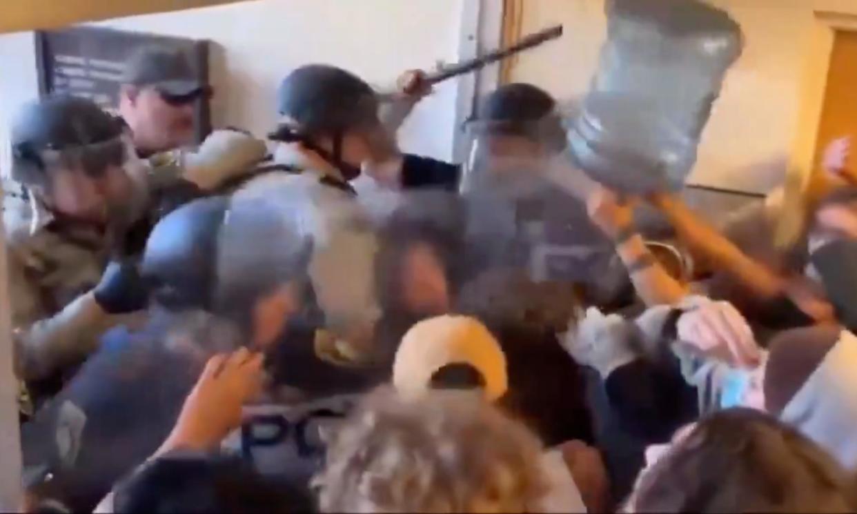 <span>Cal Poly students use a water jug to fight off police.</span><span>Photograph: Ryan Hutson at Humboldt Freelance for Redheaded Blackbelt News</span>