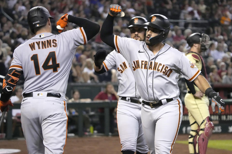 San Francisco Giants' David Villar celebrates with Austin Wynns (14) after hitting a two-run home run against the Arizona Diamondbacks during the fourth inning of a baseball game Friday, Sept. 23, 2022, in Phoenix. (AP Photo/Rick Scuteri)