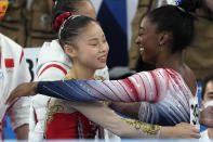 Gold medalist Guan Chenchen, of China, left, gets a hug from bronze medalist Simone Biles, of the United States, after performing on the balance beam during the artistic gymnastics women's apparatus final at the 2020 Summer Olympics, Tuesday, Aug. 3, 2021, in Tokyo, Japan. (AP Photo/Gregory Bull)
