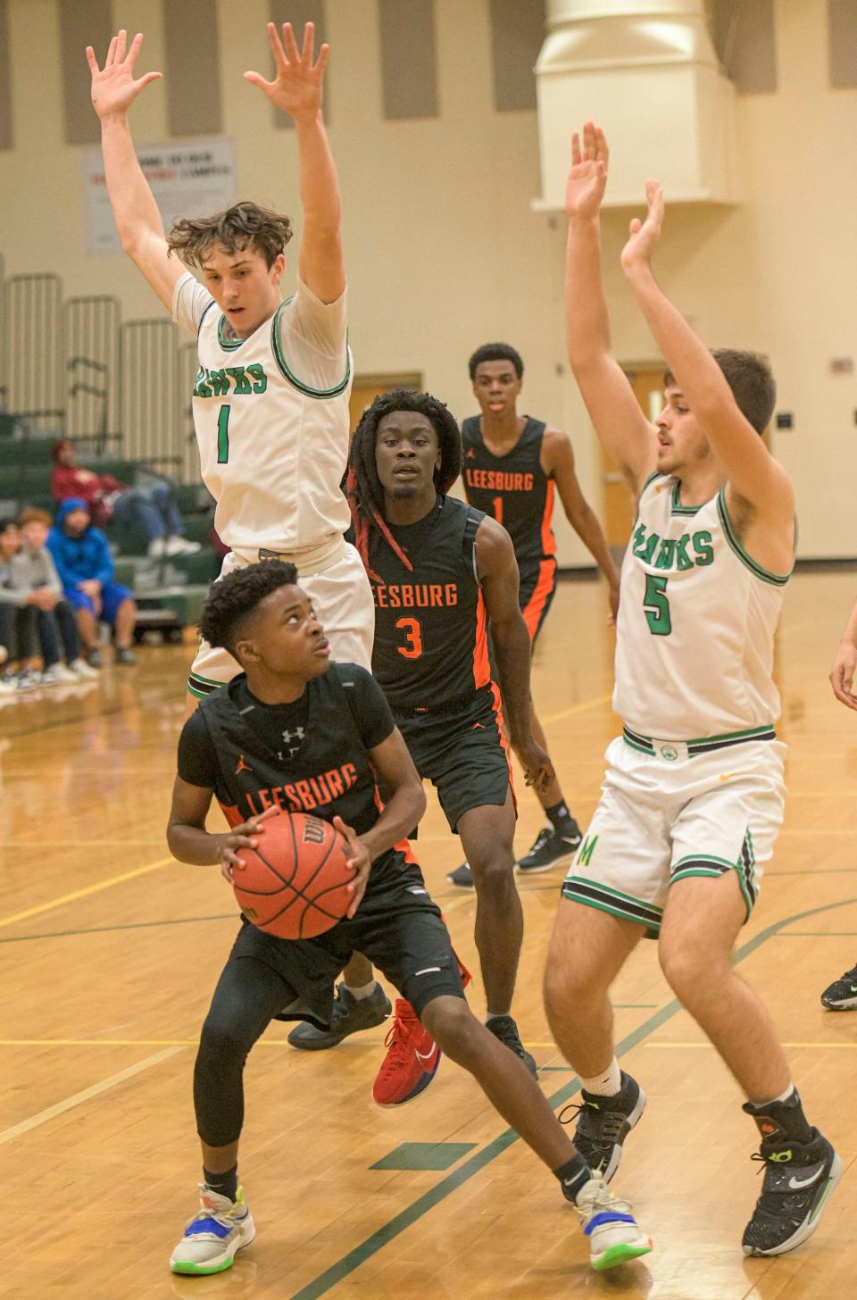 Leesburg freshman Evan James (4) eyes a shot in the lane during Tuesday's game against Lake Minneola. James scored seven points in Leesburg's 85-73 win.