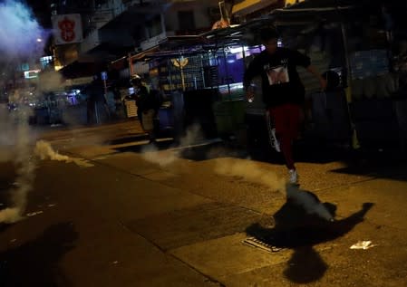 An anti-extradition bill protester runs after the police fired tear gas to disperse the demonstration at Sham Shui Po, in Hong Kong