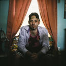 In this photo made with a medium format film camera, Joshua Messer, 29, sits for a portrait in his aunt's home where he's currently staying, days after he overdosed, in Huntington, W.Va., Tuesday, March 16, 2021. Messer was a high school basketball star, heading to college on a scholarship. He still brags that he was such a star athlete he once met the governor of West Virginia. But addiction took hold, to alcohol and pills. "I let my family down, now I'm trying to get it back together." He is covered in prison tattoos, and he likes bright colors and funny socks: he had Bugs Bunny on one foot and Mr. Potato Head on the other. He spent nine years in prison for an addiction-fueled burglary he barely remembers committing. In prison, he got 2020 tattooed on his chest because that was the year he was to be released and supposed to be the year he was to be reborn. He'd gotten a job as a cook at a restaurant and won employee of the month. He planned to save up money and open a landscaping business somewhere, get his own place and his own cat. Messer said the pandemic created a "circle of nothing," that drove him and other people he knows to using more drugs. He said he took heroin eight months ago for the first time and thought he could do it just once, but he woke up the next morning needing more. "I look at some people and it's sad how they look," he said. "I'm starting to look like that. It's sad. I'm not better than other people. But I'm better than letting something take control of my life. I feel like I should be better than this." (AP Photo/David Goldman)